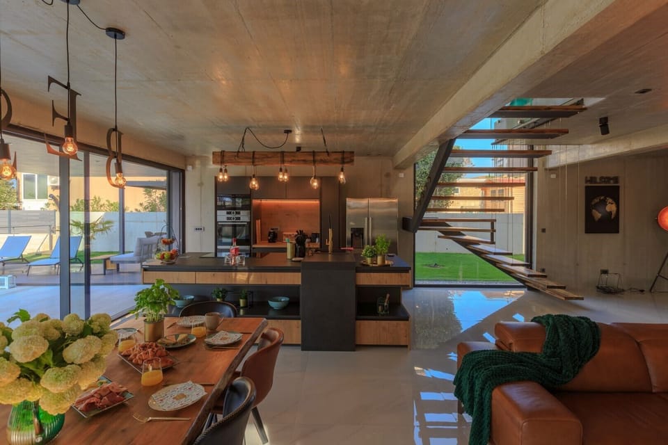 The interior of the luxury villa Krk Baska II with an open-plan wooden kitchen and a dining table