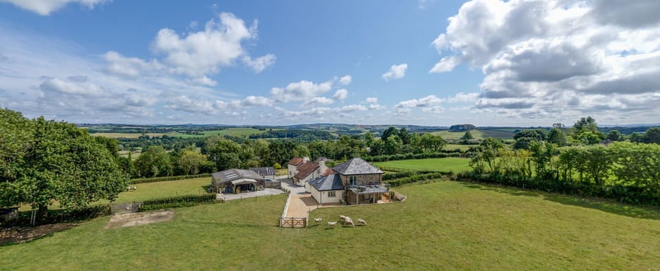 Surrounding panoramic views across wooded valleys, extending to Dartmoor