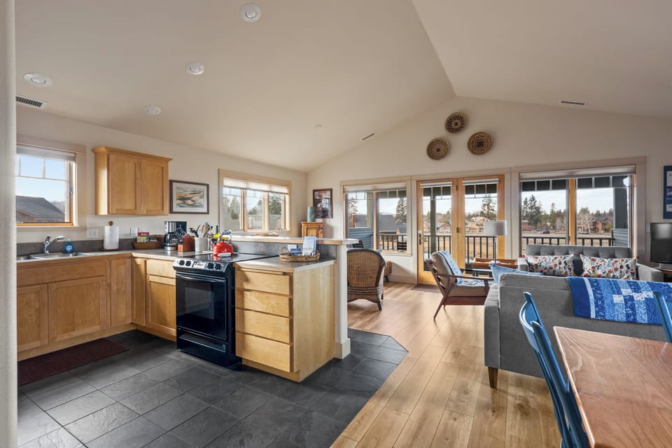 Your open-concept kitchen flows seamlessly into the living area, where warm wood cabinetry and granite counters invite you to cook memorable meals.