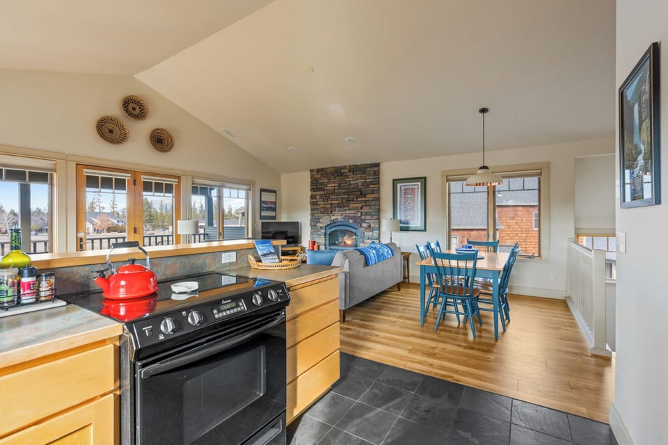 Gather around your open-concept haven where the kitchen flows into a cozy living room with stone fireplace and dining nook.