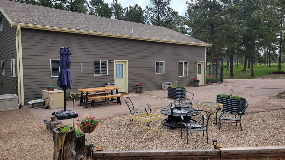 Outside photo of the guest house with a view of the patio and fire pit.