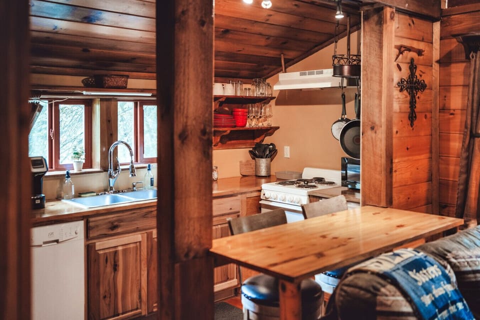 Warm wood kitchen with breakfast counter and essentials for easy meals during a romantic cabin escape