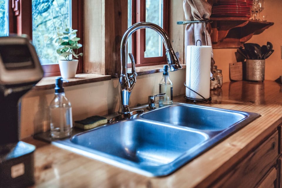 Clean double sink and warm wood counters add everyday comfort to this cozy cabin escape