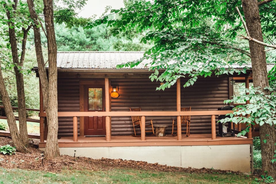 Covered private deck with rocking chairs and wooded surroundings for quiet coffee and nature-filled conversations