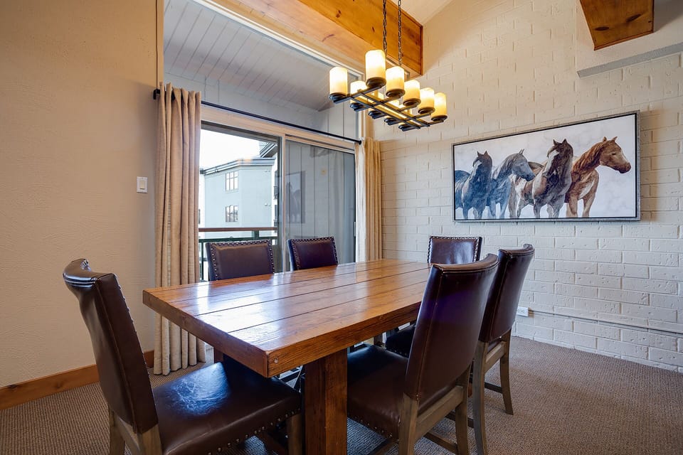 Gather around this rustic dining table for memorable meals with your group, warmed by the elegant chandelier and stunning horse artwork.