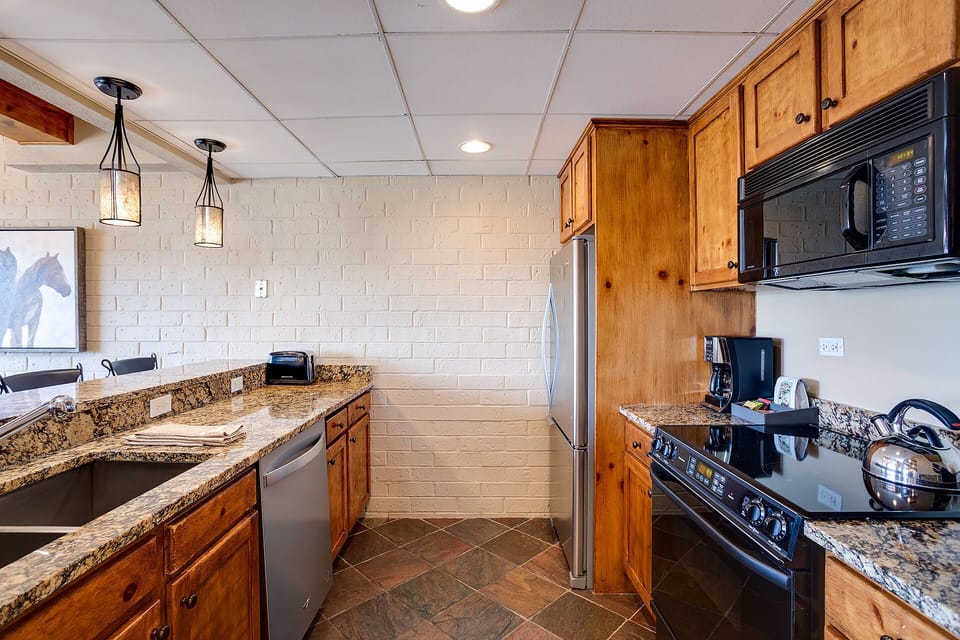 Your fully equipped kitchen features granite counters, rich wood cabinets, and everything you need to create memorable meals.