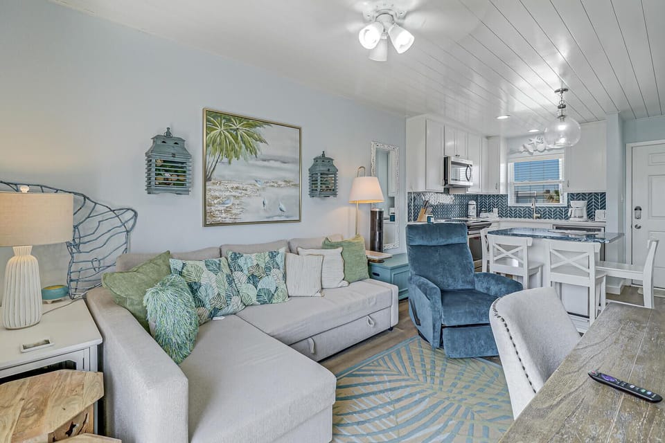Sink into your coastal-inspired living space where ocean blues meet comfort. Unwind on plush seating while preparing meals in your stylish kitchen.
