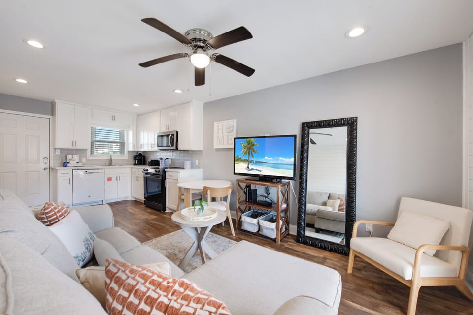 Your bright open-concept living space combines kitchen and lounge with modern comfort—perfect for unwinding with the ceiling fan's gentle breeze.