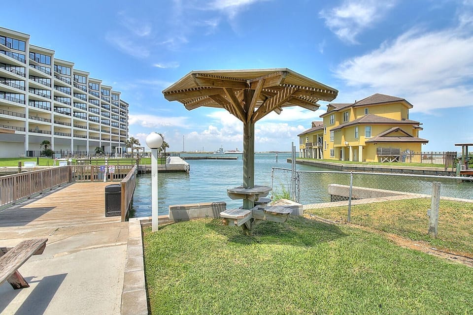 Waterfront property featuring private dock access, grassy outdoor space with shade structure, and scenic harbor views in a peaceful residential marina setting.