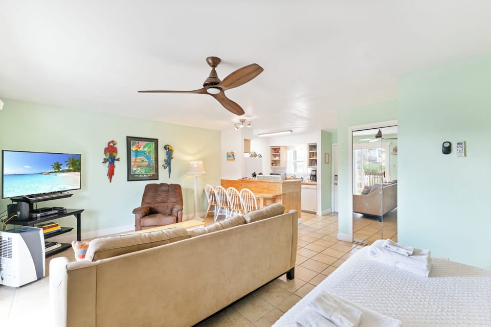 Relax in your bright, airy living space with tropical decor, comfy seating, and an open layout connecting to your fully equipped kitchen.
