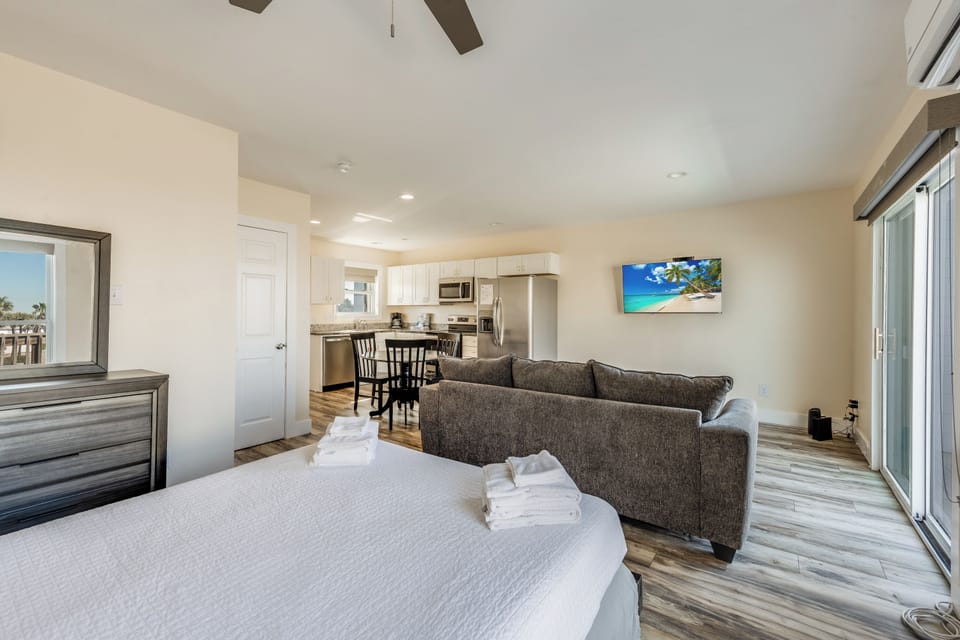 Relax in your spacious studio where comfort meets convenience—plush bedding, modern kitchen, and cozy seating create your perfect home base.