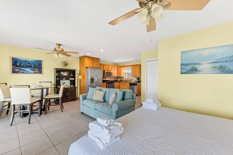 Unwind in your bright, open-concept retreat where beach vibes meet home comfort. Fresh towels await on your cozy bed while the full kitchen invites you to stay in.