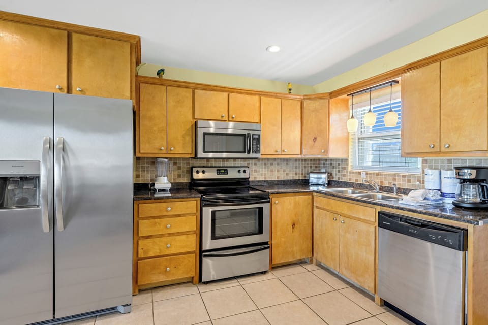 Your fully equipped kitchen features stainless steel appliances, granite countertops, and warm wood cabinetry for all your culinary adventures.