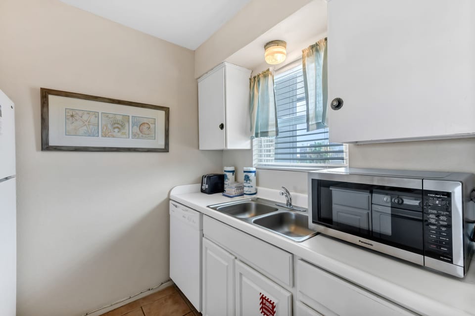 Your compact kitchenette features everything you need: microwave, coffee maker, and bright natural light from your window.