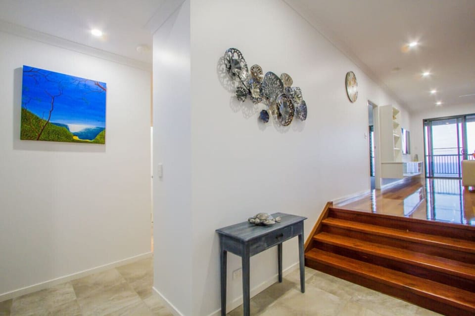 Hallway and living entry with art décor, leading to bright open living and balcony outlook.