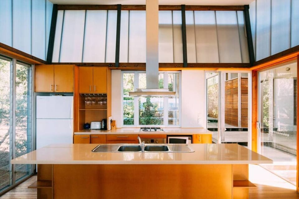 Kitchen with gas stovetop, oven, microwave, full‑sized fridge, dishwasher, and island bench, offering everything needed for a self‑contained stay.