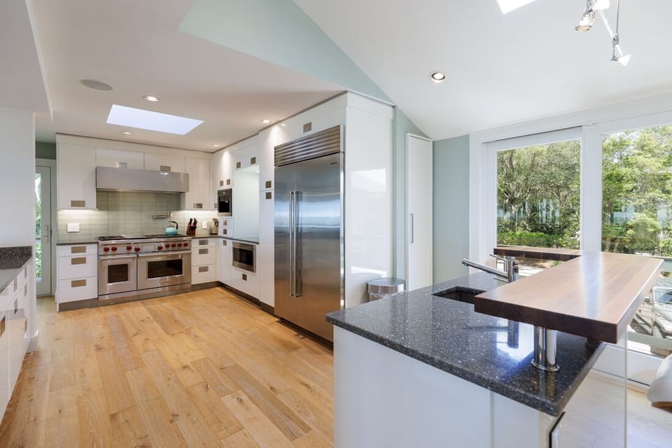 Bright and open, the space features expansive prep areas, sleek white cabinetry, and premium appliances.