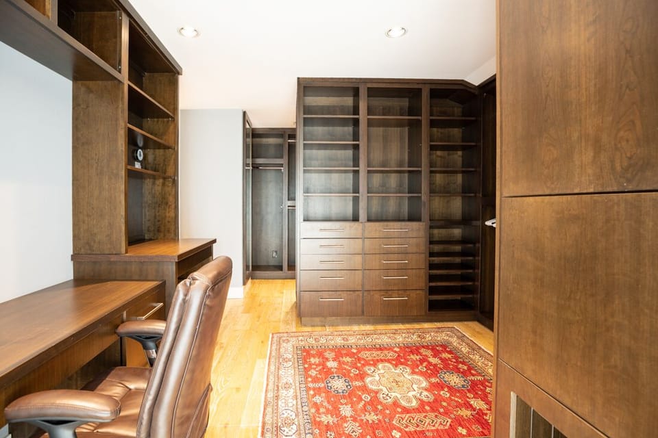 This expansive custom closet doubles as a well-appointed dressing and organizational suite.
