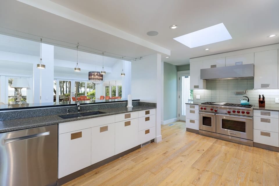 Multiple skylights and large windows fill the kitchen with natural light while offering beautiful views of the surrounding landscape.