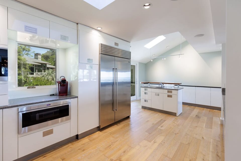 Thoughtful details such as a built-in microwave, beverage station, and a secondary island with raised bar complete this impressive culinary space.