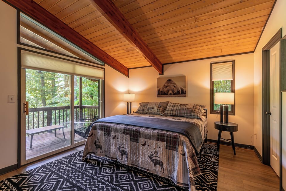 Wake up surrounded by mountain woodland. The master bedroom at Chasing Birdies opens right onto a private deck tucked into the trees.