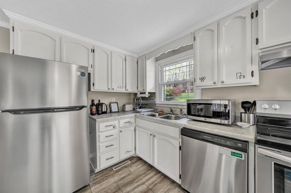 Modern kitchen with stainless steel appliances and ample natural light, perfect for cooking together