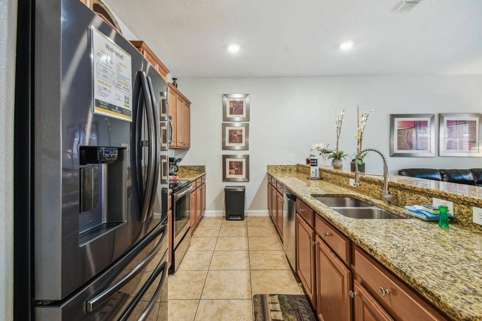 Welcome to this inviting kitchen, where rich wooden cabinetry meets sleek granite countertops, creating a warm and functional space. With modern appliances and tasteful decor, it's perfect for unleashing your culinary creativity.
