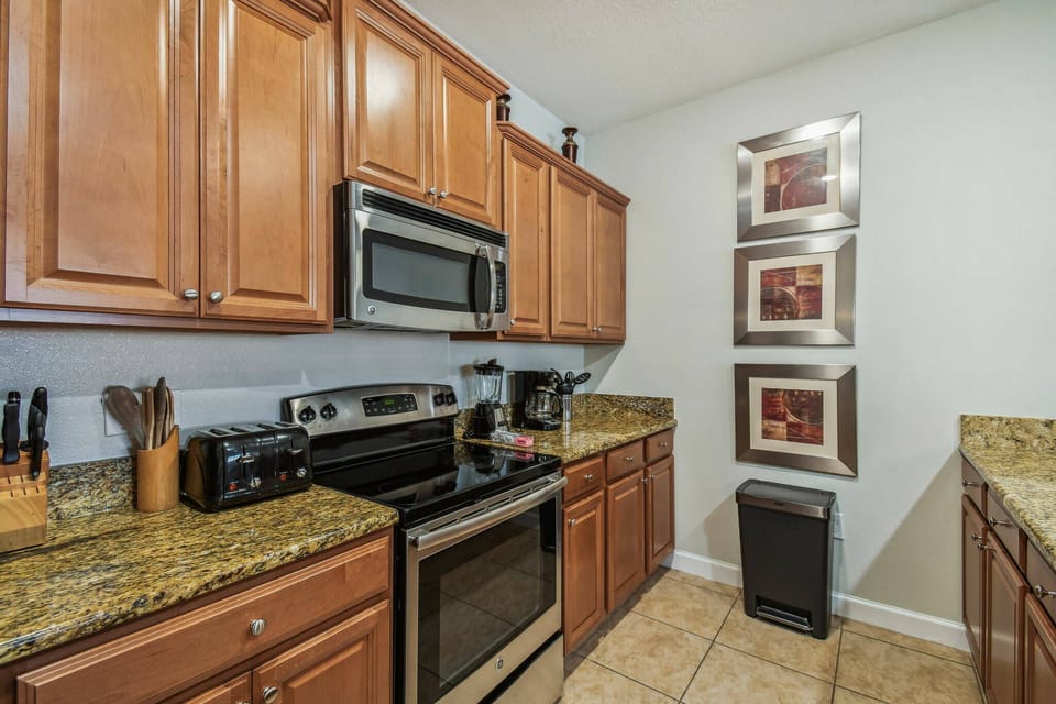 This beautifully designed kitchen boasts rich wooden cabinetry and sleek granite countertops, creating a warm, functional space. With stainless steel appliances and modern decor, it’s perfect for your culinary adventures.