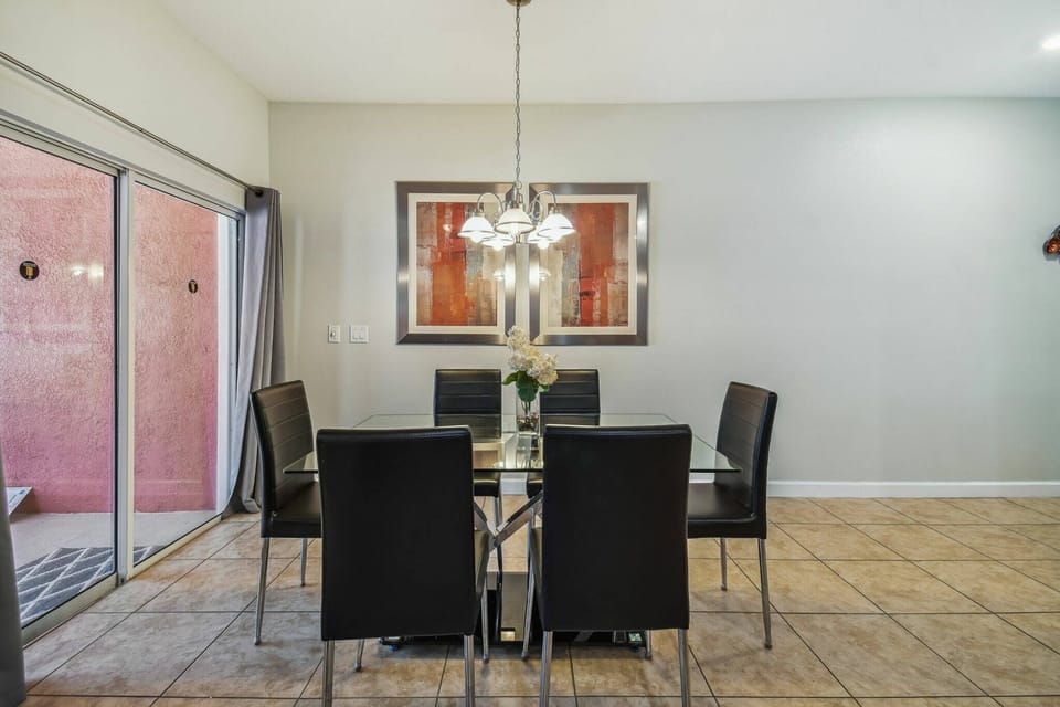 Enjoy delightful evenings in our sleek dining area, featuring a stylish glass table and contemporary black chairs. A modern chandelier adds sophistication, while large sliding doors bring in natural light and beautiful views.