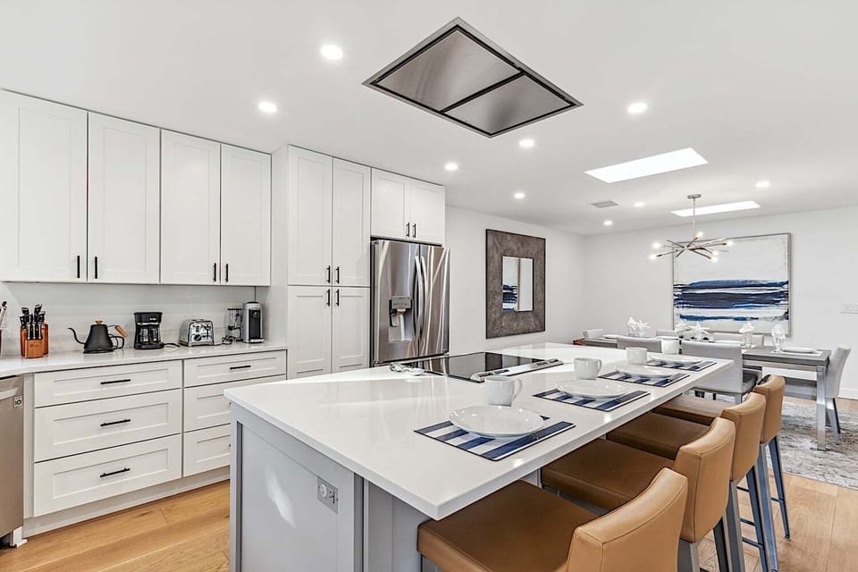 Beautiful kitchen island w/ induction cooktop and modern vent hood.