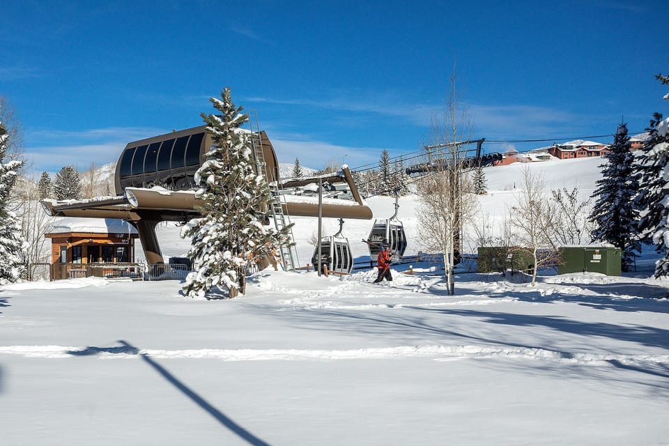 A pristine ski resort setting with modern gondola access, surrounded by snow-dusted evergreens and mountain views—winter adventure awaits just steps from your door.