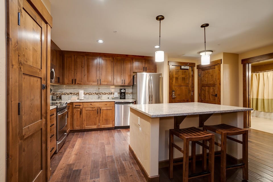 Your spacious kitchen features rich wood cabinetry, granite counters, and a welcoming island perfect for cooking memorable meals together.