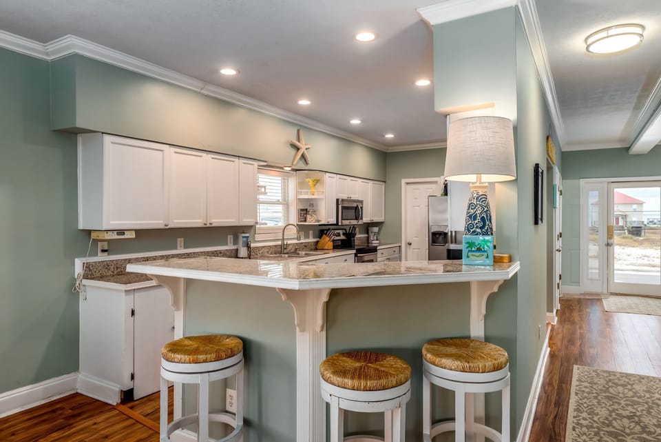 Gather around this spacious kitchen island where coastal charm meets modern convenience for memorable meal prep together.