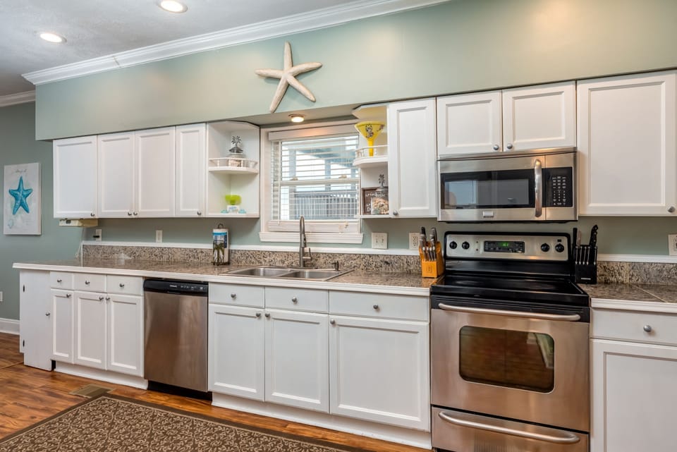 Cook your favorite meals in this bright coastal kitchen with granite counters, stainless appliances, and charming starfish décor.