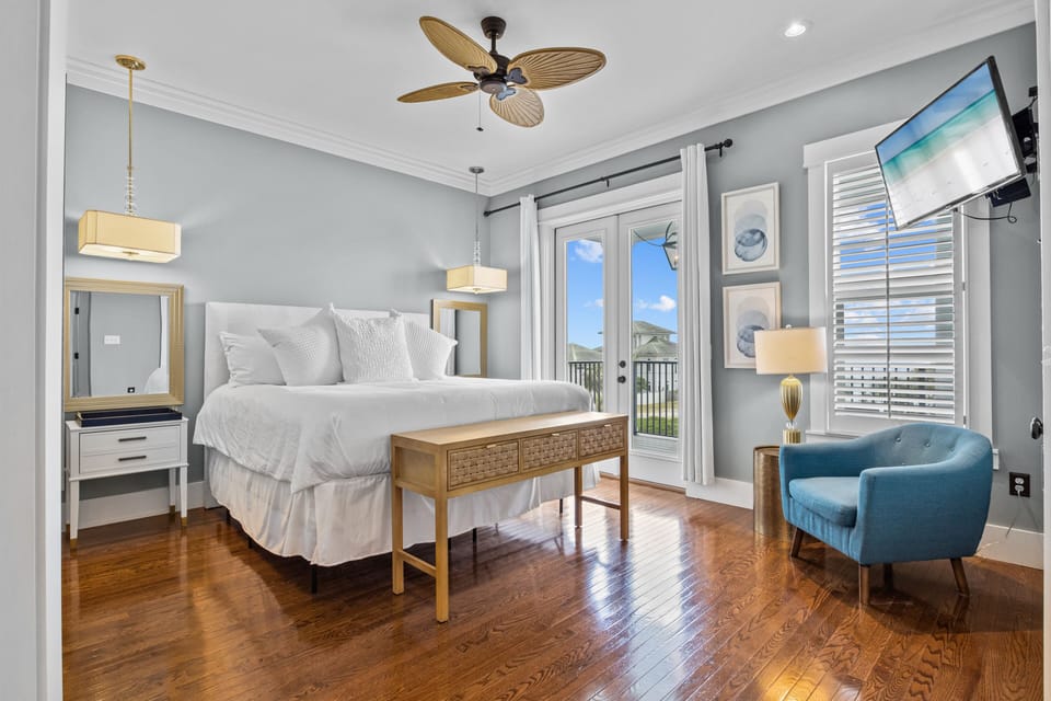 Your master bedroom offers plush bedding, private balcony access, and elegant coastal furnishings for the perfect retreat.