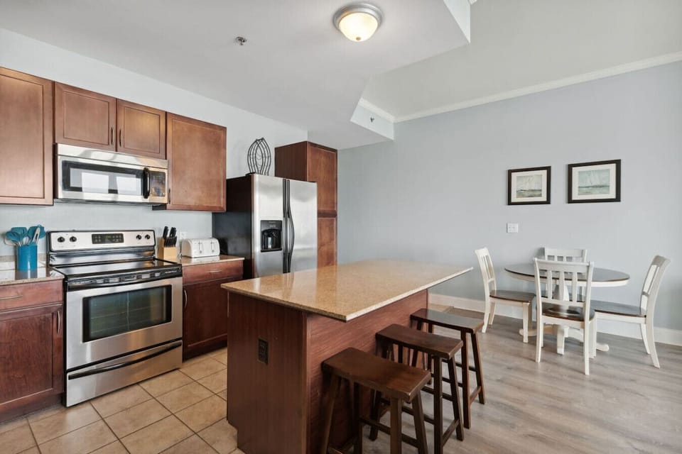 Fully stocked kitchen with island with seating for 3 and dining table with seating for 4