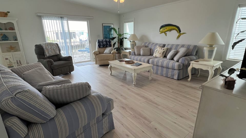 Living room with 2 recliners, comfy couch & loveseat; leads to screened porch