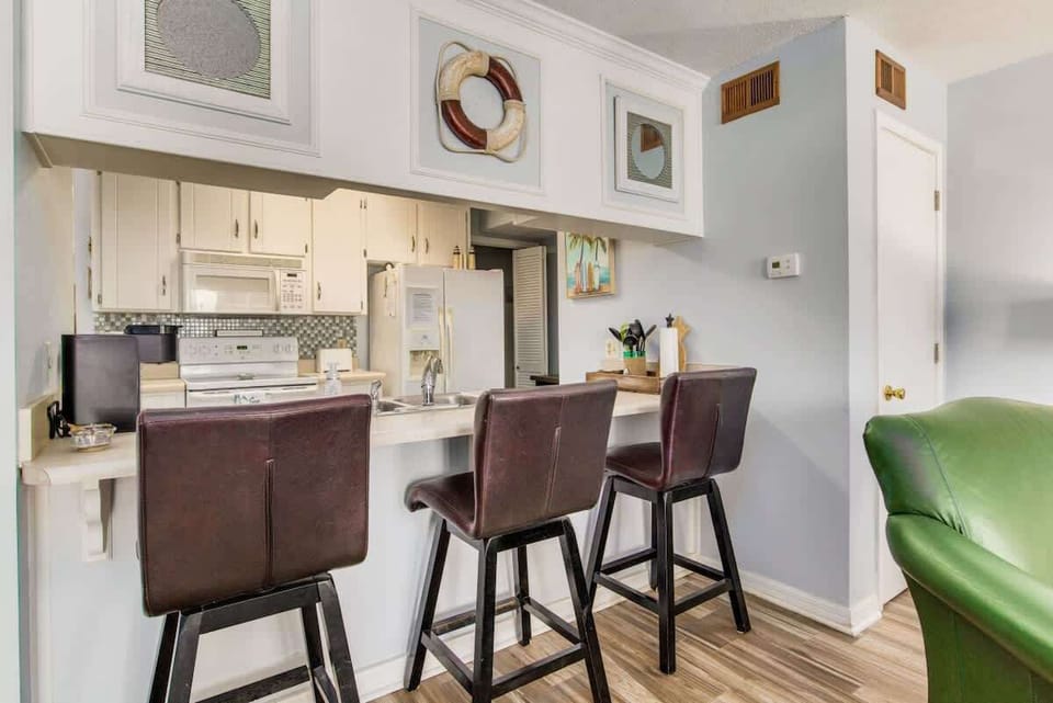 Full kitchen with bar seating, perfect for preparing meals and gathering after a day enjoying Perdido Key beaches and local coastal attractions.