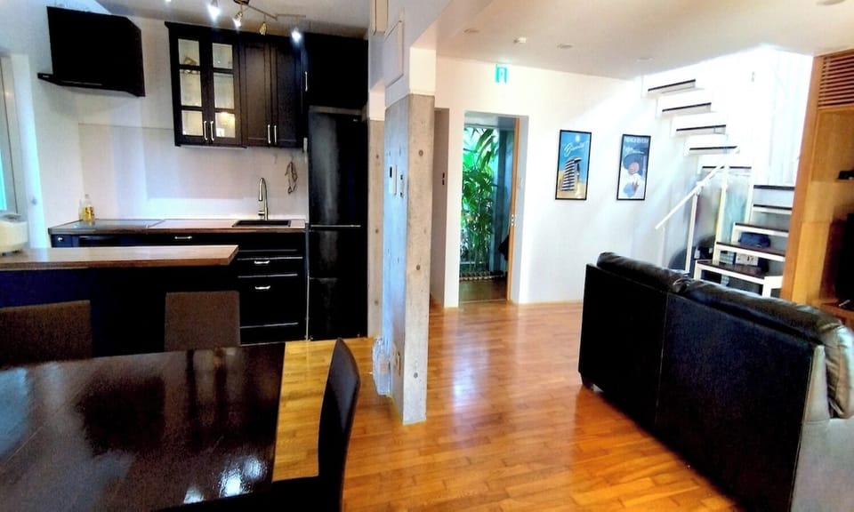 The strip staircase in the living/dining room leads to the mezzanine level. There is a sense of connection, and even from the living room you can feel the BBQ atmosphere on the balcony.