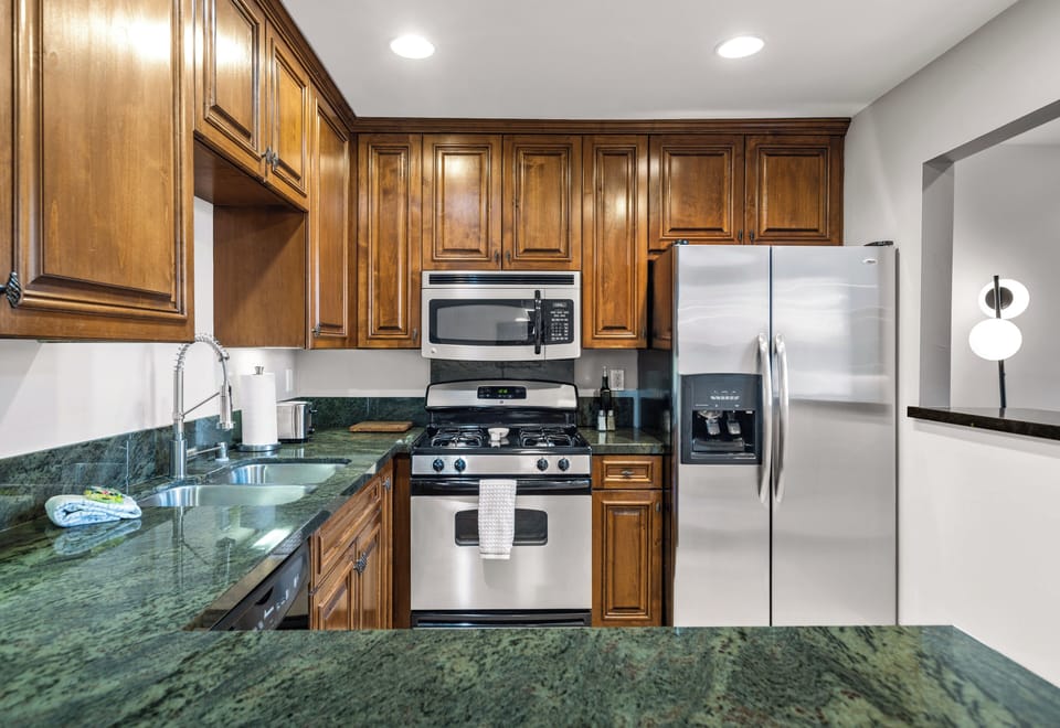 Modern kitchen with gas range, full-size fridge, and ample cabinetry