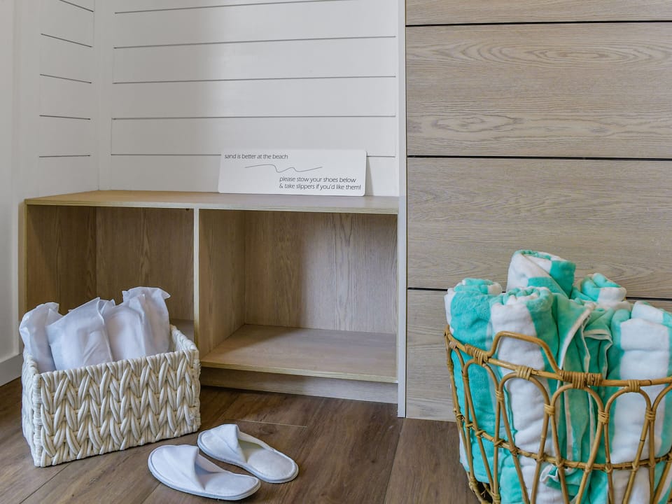 Fresh towels and slippers await in your beach entry area—perfect for sandy returns from coastal adventures.