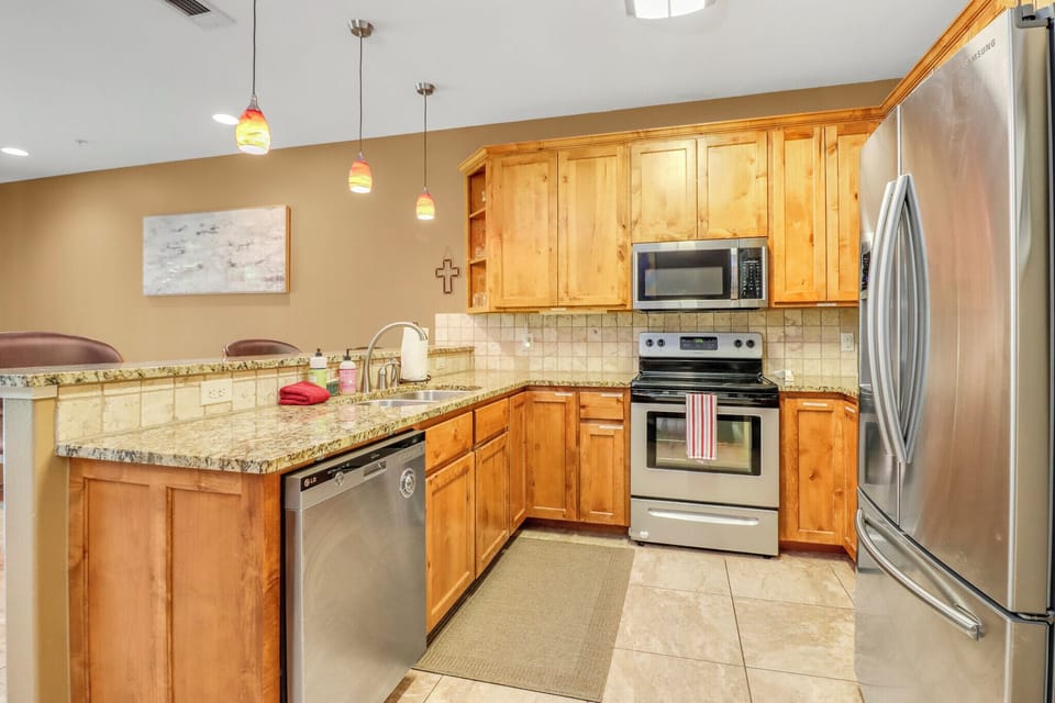 Your fully equipped kitchen features granite counters, stainless appliances, and warm wood cabinetry—everything you need to whip up home-cooked meals or quick snacks during your getaway.