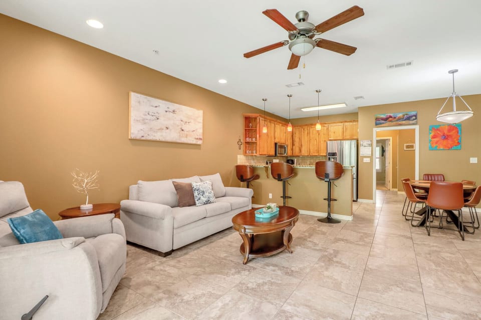 Settle into your bright, open living space with comfortable seating, a ceiling fan, and a fully equipped kitchen just steps away—everything you need to feel right at home.