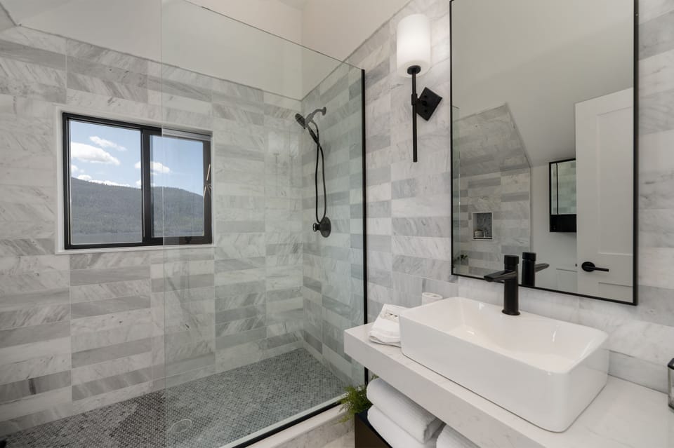 The primary bathroom is beautifully done in marble, with a spacious, oversized shower to enjoy
