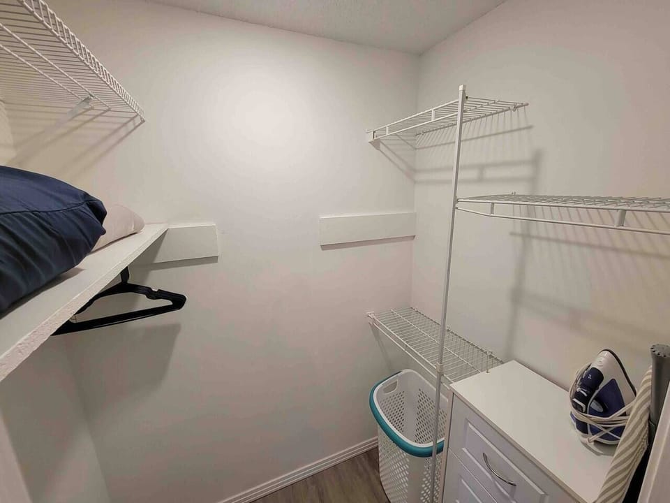 Master bedroom closet. Ironing board and iron.  Extra pillows and blankets provided in each bedroom.