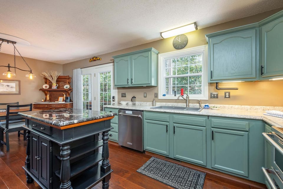 Updated kitchen with KitchenAid dishwasher, Crock Pot, Blender, Mixer, Drip-style coffeemaker, induction range with dual ovens, and bar seating for 3.