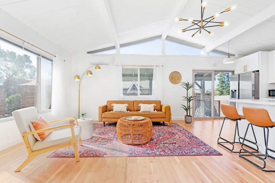 Bright boho-inspired living room with vaulted ceilings, abundant natural light, and comfortable seating.