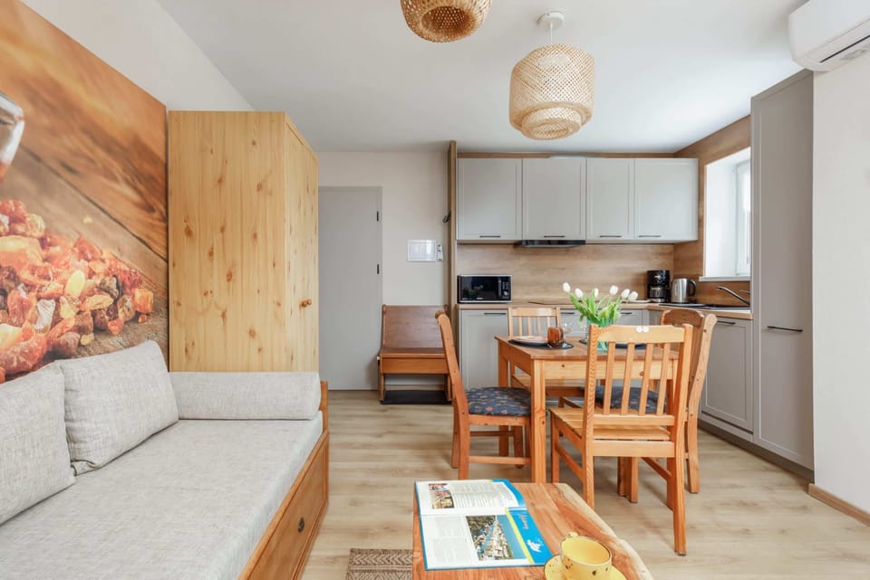 A cozy living space with a wooden sofa, bright cushions, and a rustic vibe complemented by slanted ceilings and natural wood details.