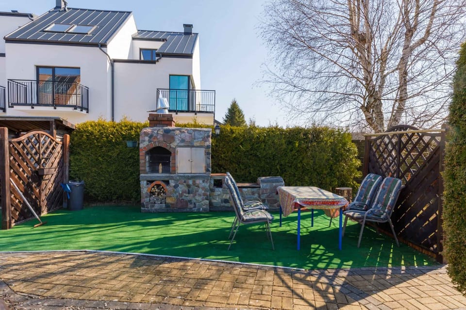 A patio area with a garden table and chairs, perfect for outdoor relaxation. The lush green surroundings add tranquility.
