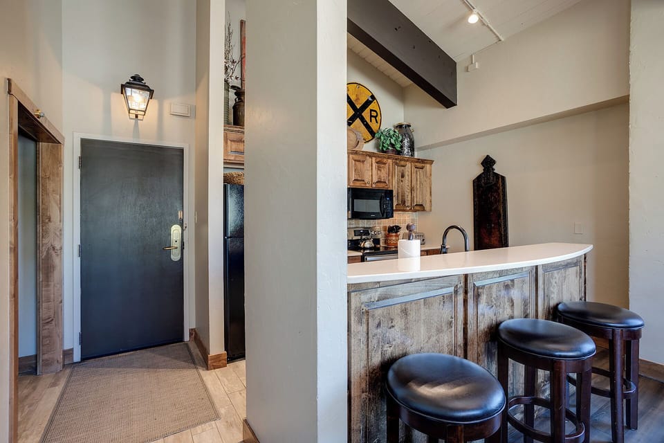 Gather around your rustic kitchen island with comfy bar stools, perfect for morning coffee or evening conversations in this charming space.